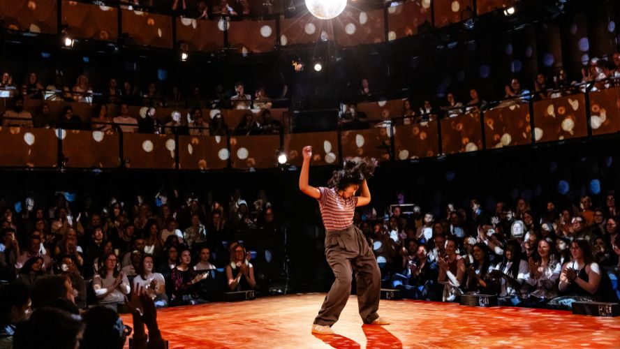 Ambika Mod dancing on stage @sohoplace under a large, silver disco ball